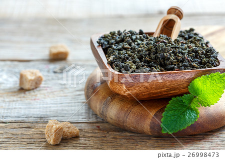 Green tea Oolong, shovel in bowl and melissa. 26998473