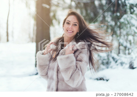 Beautiful woman on snowing cold winter day in 27008642