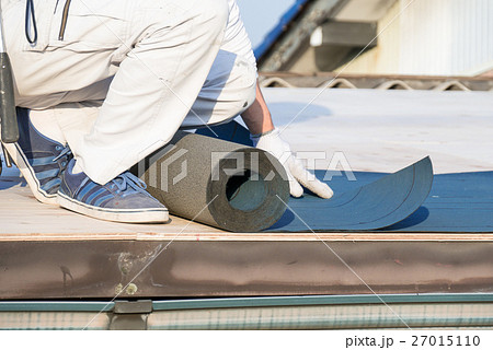 屋根工事 防水シートを貼る職人の写真素材