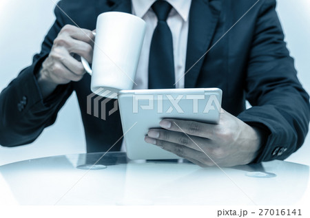 Closeup Businessman holding tablet, coffee cup and working on the work place, business concept Closeup Businessman holding tablet, coffee cup and working on the work place, business concept 27016141
