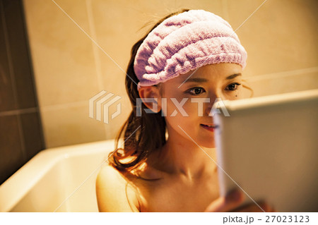 半身浴をしながらタブレットを見る女性 半身浴をしながらタブレットを見る女性 27023123