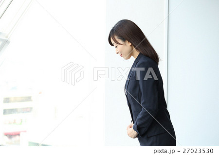 お辞儀をするスーツの女性の写真素材