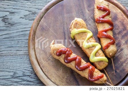 Corn dogs on the wooden board 27025821