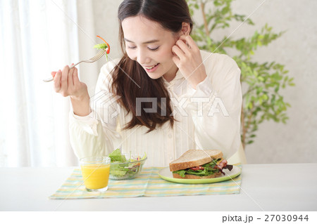 朝食のサンドイッチを食べる女性 朝食のサンドイッチを食べる女性 27030944