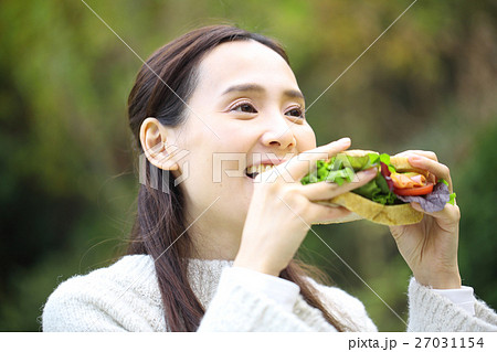 昼食のサンドイッチを食べる女性の写真素材