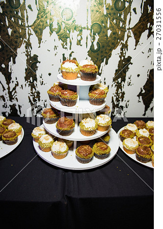Cupcakes with cream served in tired dish Cupcakes with cream served in tired dish 27031556