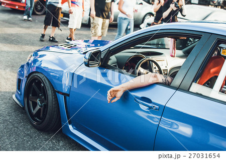 Man sits in blue BMW on the street Man sits in blue BMW on the street 27031654