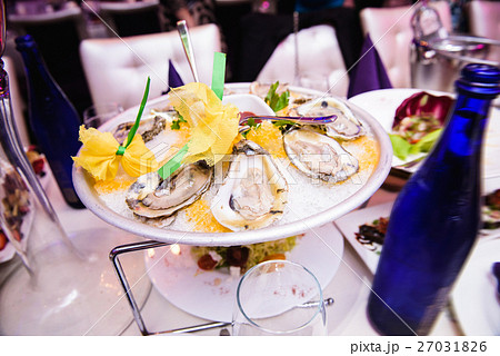 Mussels with lemon stand on plate with ice 27031826