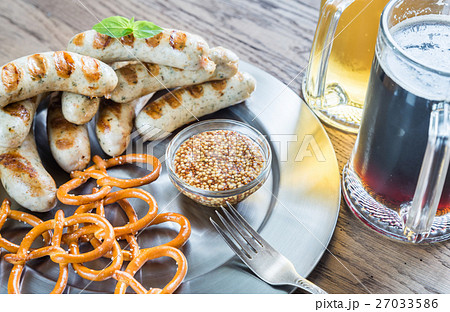 Grilled sausages with pretzels and mugs of beer Grilled sausages with pretzels and mugs of beer 27033586