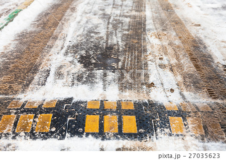 speed bump in snow on urban road in winter 27035623