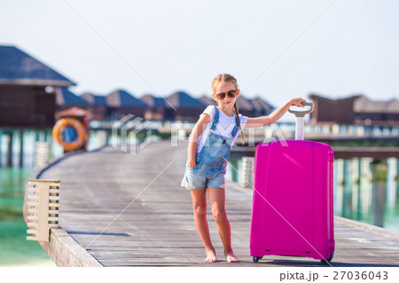 Little adorable girl with big luggage near water Little adorable girl with big luggage near water 27036043