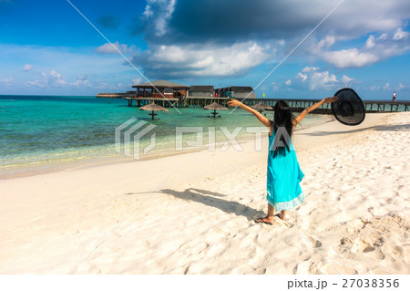 Portrait of happy young woman at beautiful water villa at Maldives island. Travel and Vacation. Outdoor shot. 27038356