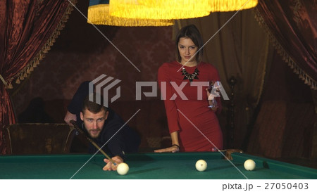 Beautiful happy couple playing billiards 27050403