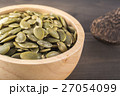 Close-up green pumpkin seeds in a wooden cup 27054099