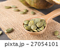Green pumpkin seeds in a wooden spoon 27054101