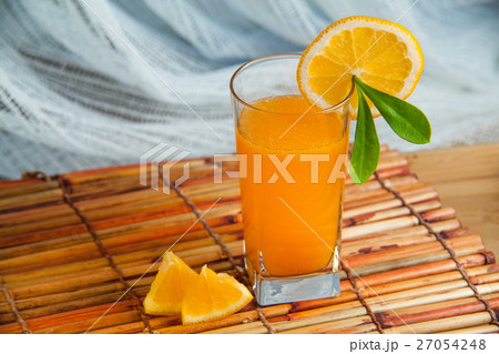 Fresh squeezed orange juice with sliced oranges. 27054248