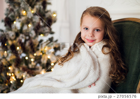 Cute little girl sits by the christmas tree Cute little girl sits by the christmas tree 27056576
