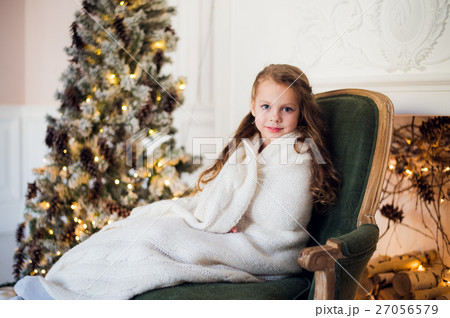 Cute little girl sits by the christmas tree Cute little girl sits by the christmas tree 27056579
