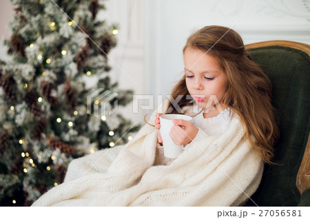 Little girl wearing pajama sitting on armchair 27056581