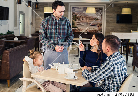 restaurant and holiday concept - waiter giving restaurant and holiday concept - waiter giving 27057393