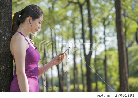 woman listening music after jogging in the forest woman listening music after jogging in the forest 27061291