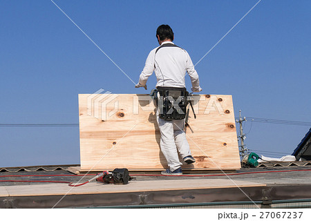 屋根工事 コンパネを持って歩く屋根職人 27067237