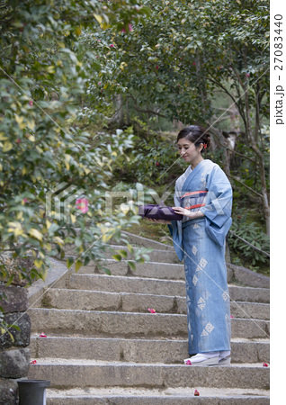 石階段に立つ小包を持つ着物を着た女性の写真素材