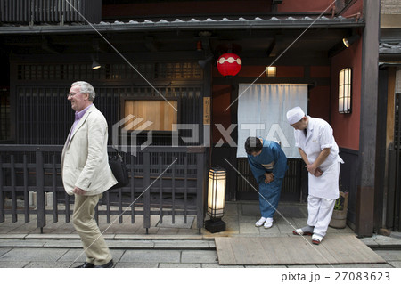 外国人客にお辞儀をする板前と女将 27083623