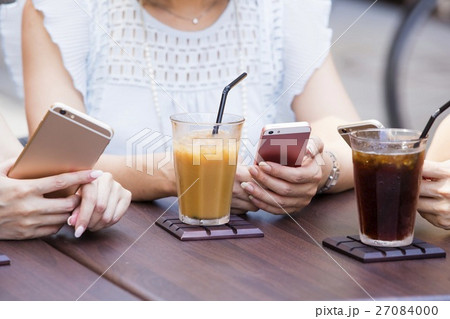 オープンカフェでスマホを操作する女性 27084000