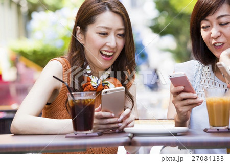 オープンカフェでスマホを操作する女性 27084133