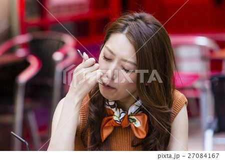 オープンカフェでケーキを食べる女性 27084167