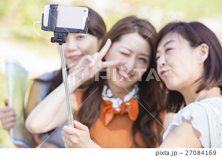 自撮り棒で写真を撮る女性 自撮り棒で写真を撮る女性 27084169