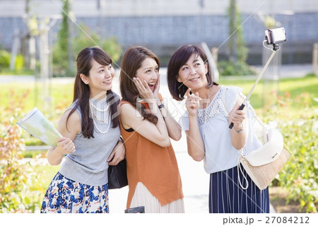 自撮り棒で写真を撮る女性 27084212