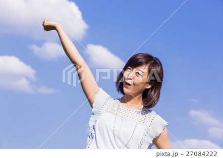 青空を背景に立つ女性 27084222