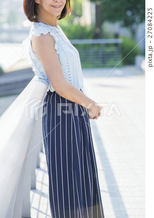 街中の川沿いに立つ女性 街中の川沿いに立つ女性 27084225