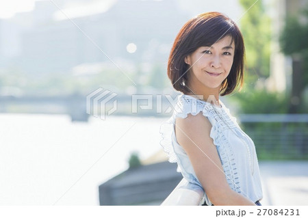 街中の川沿いに立つ女性 街中の川沿いに立つ女性 27084231