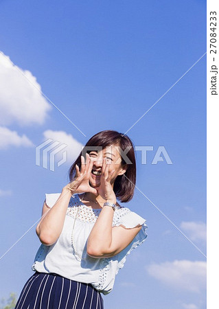 青空を背景に立つ女性 27084233