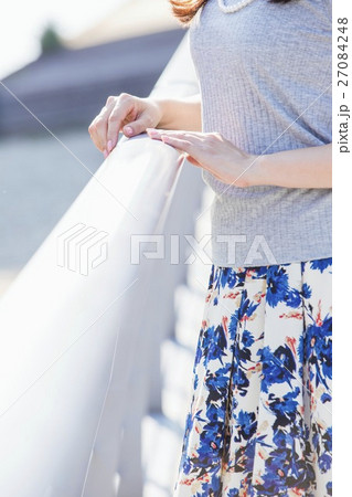 街中の川沿いに立つ女性 27084248