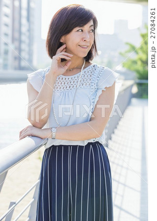 街中の川沿いに立つ女性 街中の川沿いに立つ女性 27084261