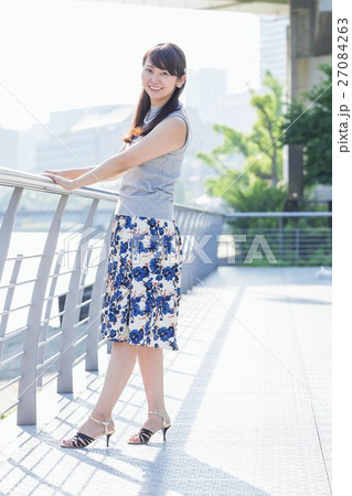 街中の川沿いに立つ女性 27084263