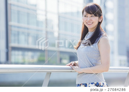 街中の川沿いに立つ女性 街中の川沿いに立つ女性 27084286