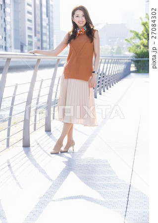 街中の川沿いに立つ女性 27084302