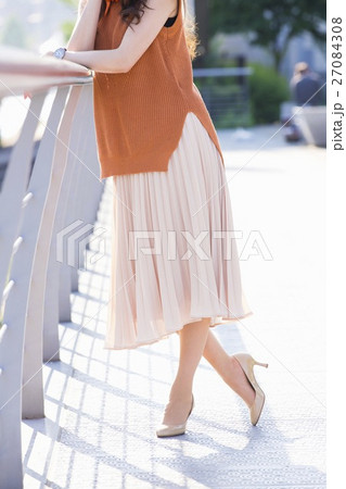 街中の川沿いに立つ女性 27084308