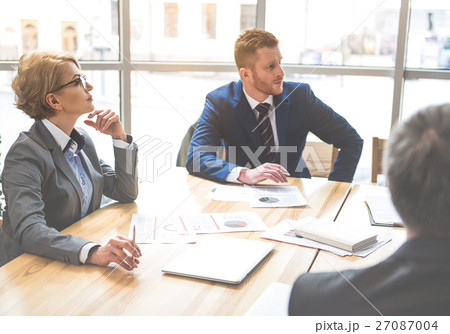 Confident people sitting at the office Confident people sitting at the office 27087004