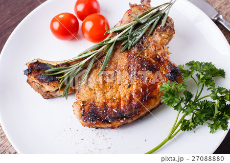 Grilled rib steak with rosemary on white dish Grilled rib steak with rosemary on white dish 27088880