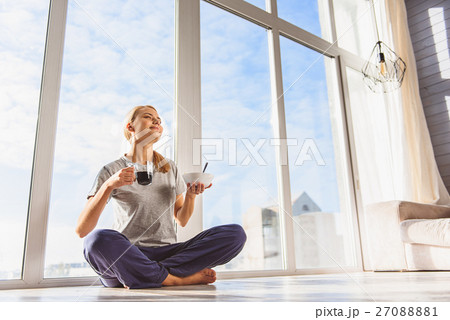 Carefree woman having breakfast at home 27088881