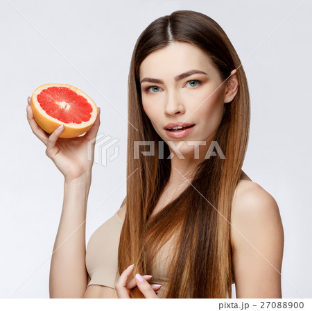 Beautiful Woman with Clean Fresh Skin holding 27088900