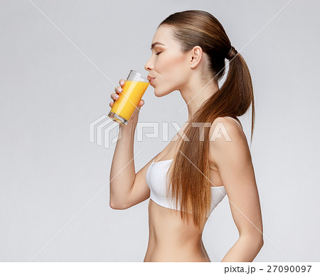 sporty woman over gray background holding glass of sporty woman over gray background holding glass of 27090097