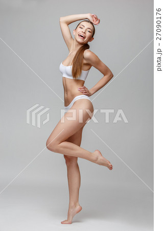 Slim tanned woman's body over gray background 27090176