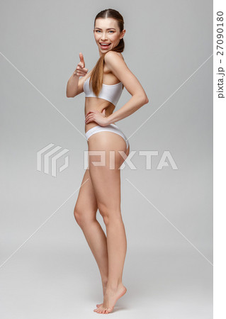 Slim tanned woman's body over gray background Slim tanned woman's body over gray background 27090180